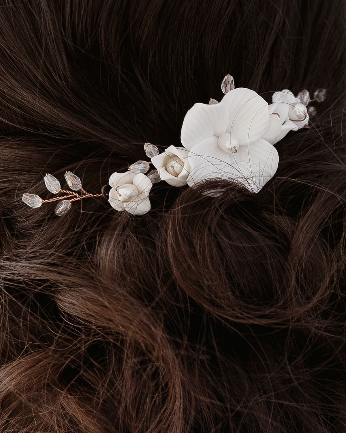 Detailaufnahme des kleinen Alba Haarkamms mit wei&szlig;en Bl&uuml;ten in einer Half-up Brautfrisur