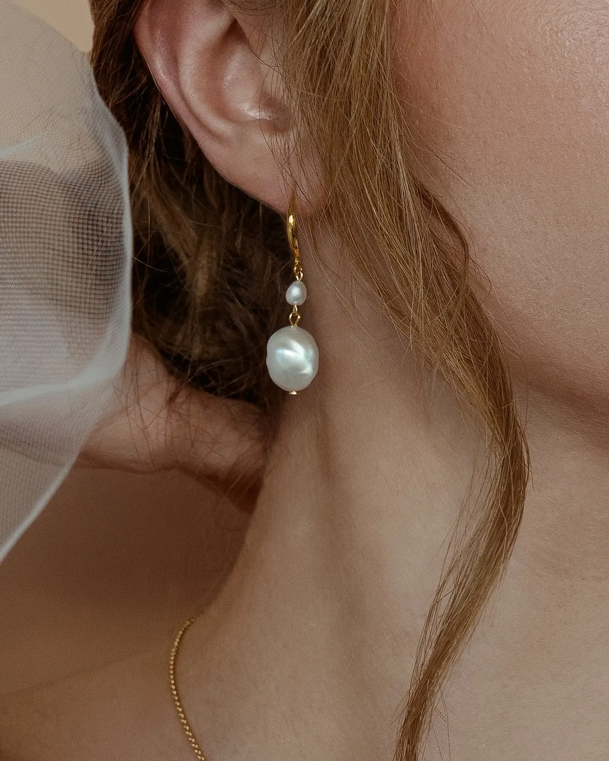 Nahaufnahme der FREYA Ohrringe am Ohr, modernes Schmuck-Design aus Sterling Silber mit 18K Vergoldung und organischen Perlen, handgefertigt in der Sternenauge Manufaktur